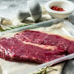 Fresh meat, vacuum-Packed marbled beef, sirloin steak. Dark background. Packaging from super market
