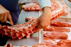 Butcher Preparing Meat In Shop Butcher cut meat in a meat shop